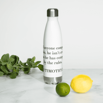 Bilingual stainless steel water bottle with English (2 Timothy 2:5) white 17 oz back view on white table with lemon & lime
